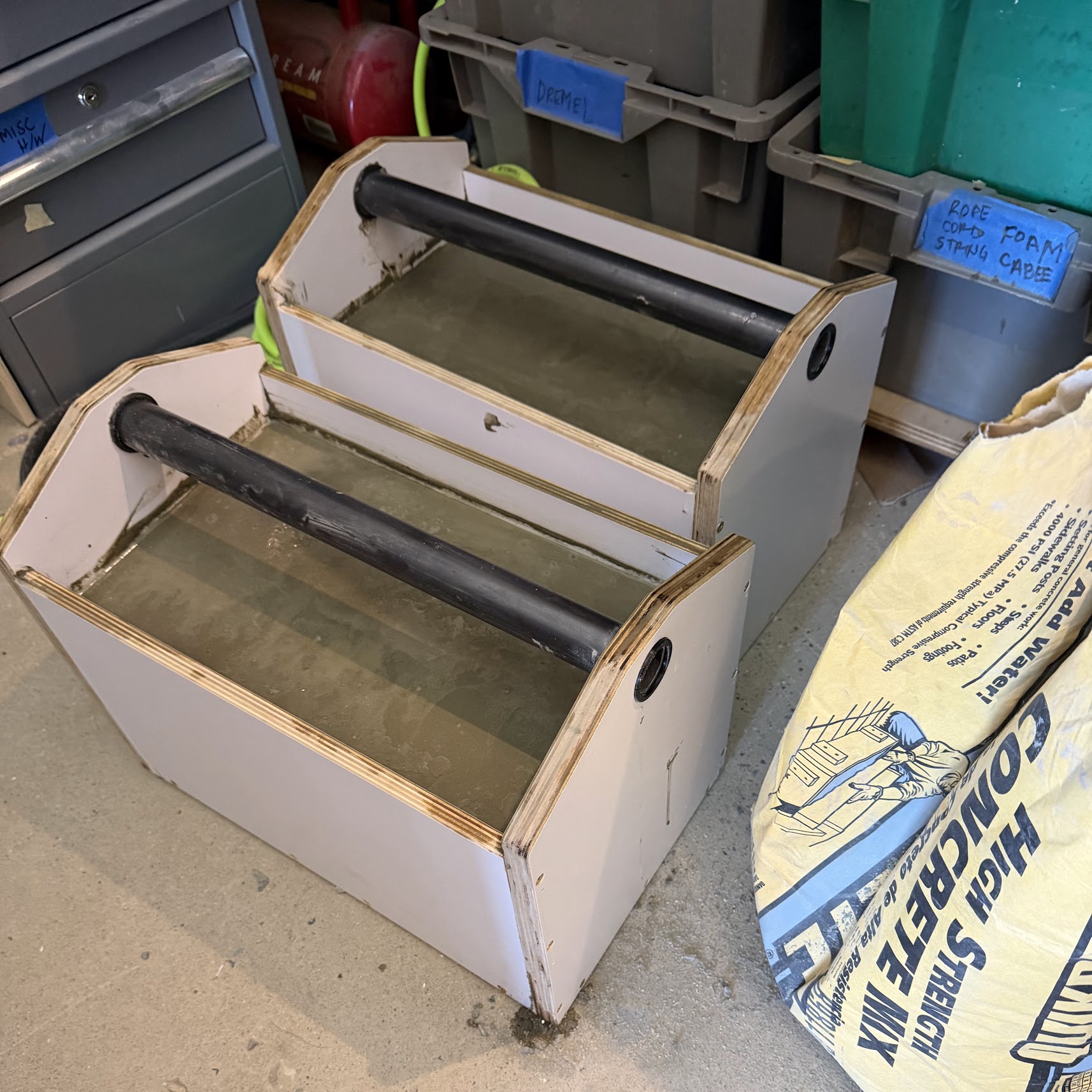 Finished pair of farmer's carry boxes sitting on a Persian rug, three-quarter view, melamine sides clean, plywood edges visible.
